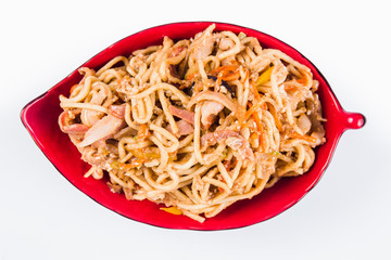 noodles with bacon and pepper on a red plate on a white background. Traditional Italian pasta. Close top view