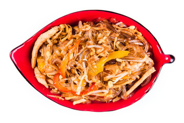 Thick glass noodles with chicken pepper and sesame seeds on a red plate on a white background. Traditional Italian pasta. Close top view