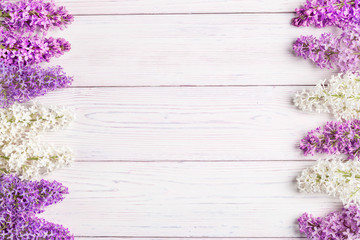 Floral pattern lilac branches and petals on wooden background. Frame.