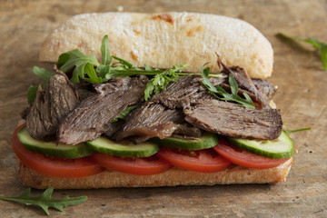 roast beef sandwich with tomato cucumber arugula