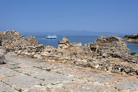 Greece, Aegina: Ferry boat seen from famous Temple of Apollo in midday sun with sea ocean Saronic Gulf and blue sky. Aegina is one of the beautiful Saronic Islands of Greece in the Greek Saronic Gulf.
