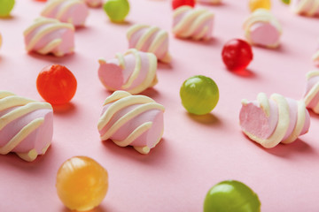Fototapeta na wymiar Closeup of marshmallows and colourful sweets on pink background