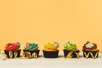 Chocolate cupcakes in a row with colourful icing