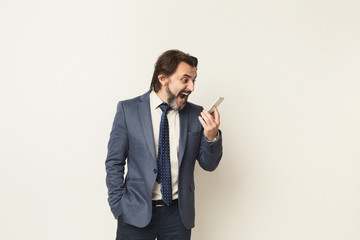 Angry businessman crying on phone at white background