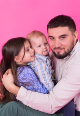 Fototapeta premium Father with children having fun on pink background