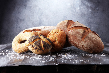 Different kinds of bread and bread rolls on board from above. Kitchen or bakery poster design.