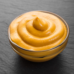 mustard in a bowl on a rustic background