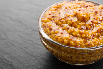 mustard in a bowl on a rustic background