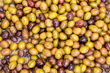 Background of green and black olives in pickle sold on the market