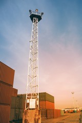 Cargo containers stacked in port. Container port or terminal and tower lamp.