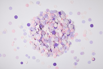 top view of pile of violet confetti pieces on white surface