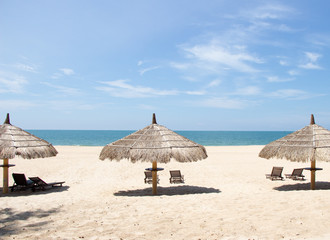 Tropical view of a beach with umbrellas and  beach chairs