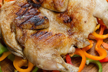 Fried crusted grilled chicken on a colorful background of vegetables