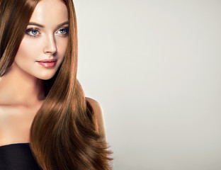 Beautiful brunette girl with long straight smooth hair . A woman with healthy straight hairstyle 
