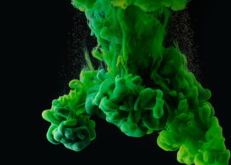 close-up view of green abstract ink explosion on black background