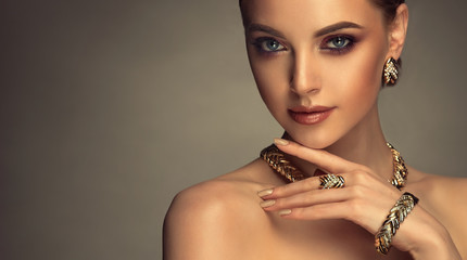 Beautiful girl with set jewelry . Woman in a necklace with a ring, earrings and a bracelet. Beauty...