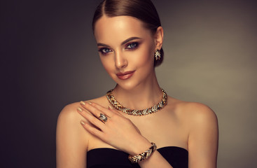 Beautiful girl with set jewelry . Woman in a necklace with a ring, earrings and a bracelet. Beauty and accessories. 
