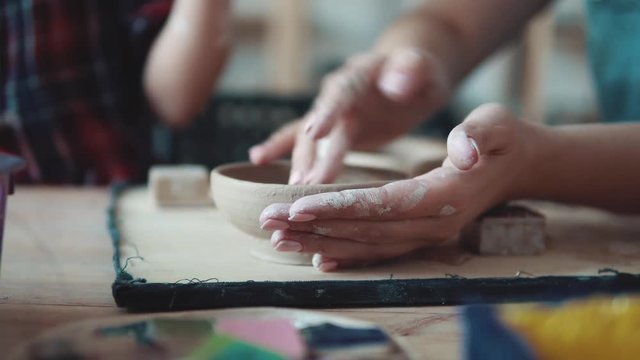 girl sculpts a clay plate. occupation on manual modeling of clay. female hands close-up.