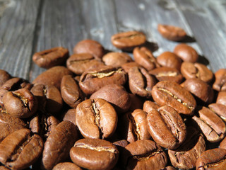 Roasted coffee beans on a wooden table, macro shot