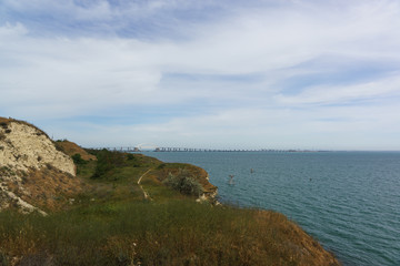 Fototapeta na wymiar Seashore and the Crimean bridge across the Kerch Strait