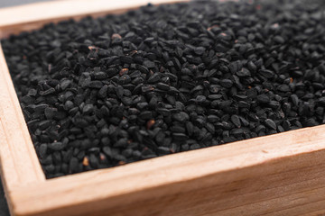 grains of black cumin and oil on the rustic background