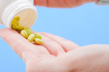 Close up woman pours the pills out of the bottle. Medicine and health care.