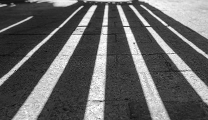 Obraz premium Vertical Lines as Shadows on the stone road Black and white pattern as background
