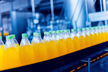 Conveyor with bottles for juice or water. Beverages factory equipments