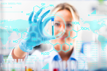 Young attractive female scientist examining test tube with substance probe