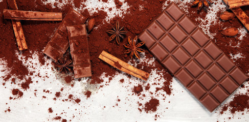 Chocolate bars on table with chocolate powder.