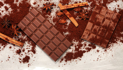 Chocolate bars on table with chocolate powder.