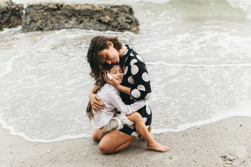 Mother and daughter holding hands and walking on beach. Mom and dauther happy family lifestyle concept