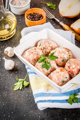 Raw homemade chicken or turkey meatballs in baking dish dark rusty background. Copy space