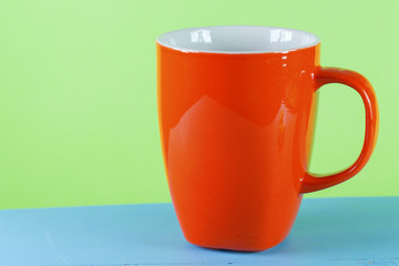 empty coffee cup on green background with copy space 