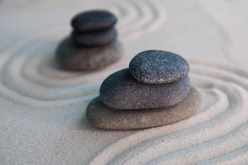 Pyramids of gray zen stones on light sand. Concept of harmony, balance and meditation, spa, massage, relax