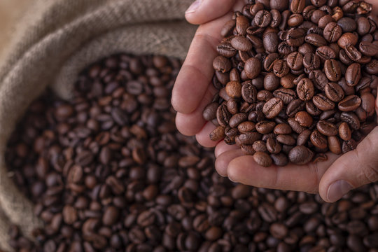 Hands on a sack of coffee beans