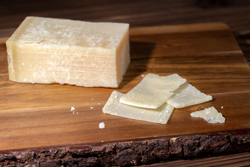 portion and slaced of fresh parmesan cheese on wooden table