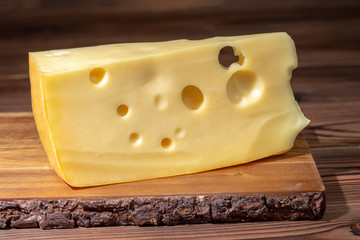 portion of fresh maasdam cheese on wooden table