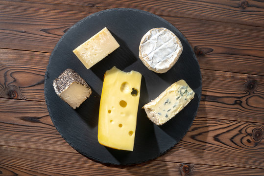 top view of portions cheese on wooden table, Italian, French food, concept of dairy products