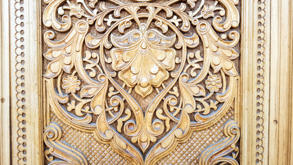amazingly beautiful traditional Uzbek floral ornament carved on the wooden door of the mosque