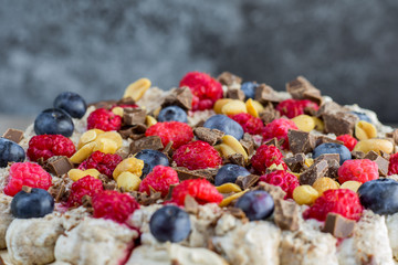 Detailed view on a peaches, chocolate, raspberries and blueberries on a cake