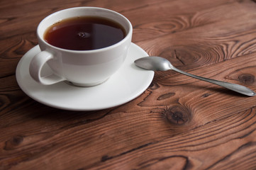 Obraz premium White cup of black tea or coffee on vintage wooden table
