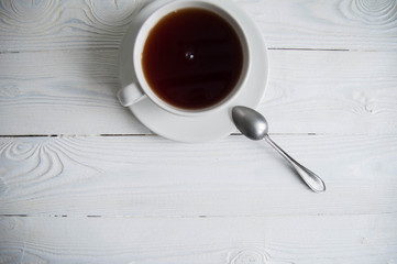 White cup of black tea or coffee on vintage wooden table