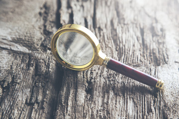 Magnifying glass on wood table background