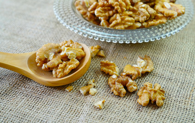 Kernel walnuts in a bowl and wooden spoon on sackcloth