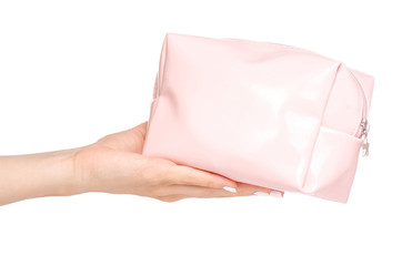 A female cosmetic bag in hand on a white background isolation