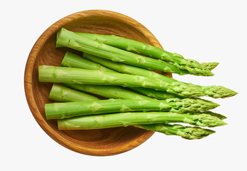 Fresh green shoots of asparagus in a wooden bow