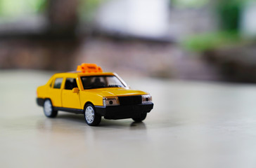 Fototapeta na wymiar Yellow old taxi car on road on blurred background