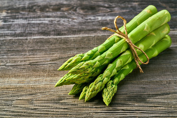 Fresh green shoots of asparagus on a gray wooden background