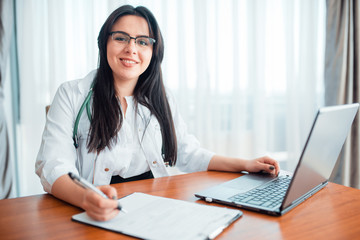 Family doctor concept, specialist sits at laptop